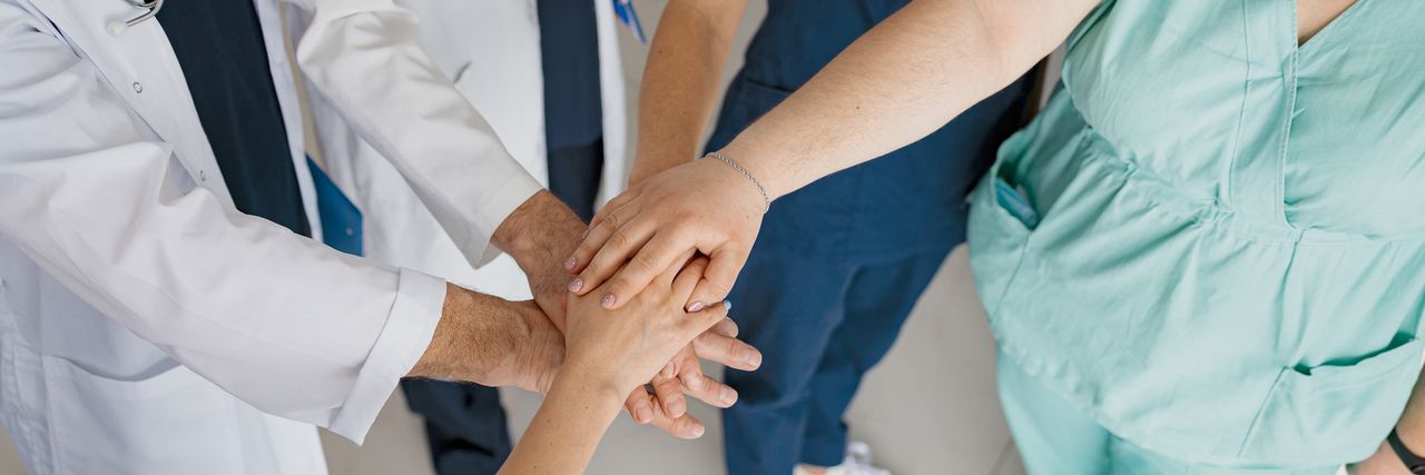 Des soignants réunissent leurs mains en signe d'entraide