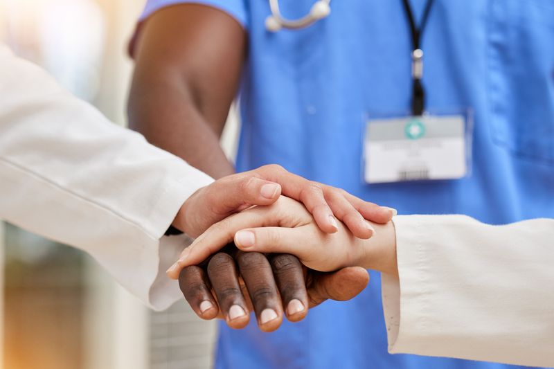 Une équipe médicale réunit ses mains en signe de collaboration